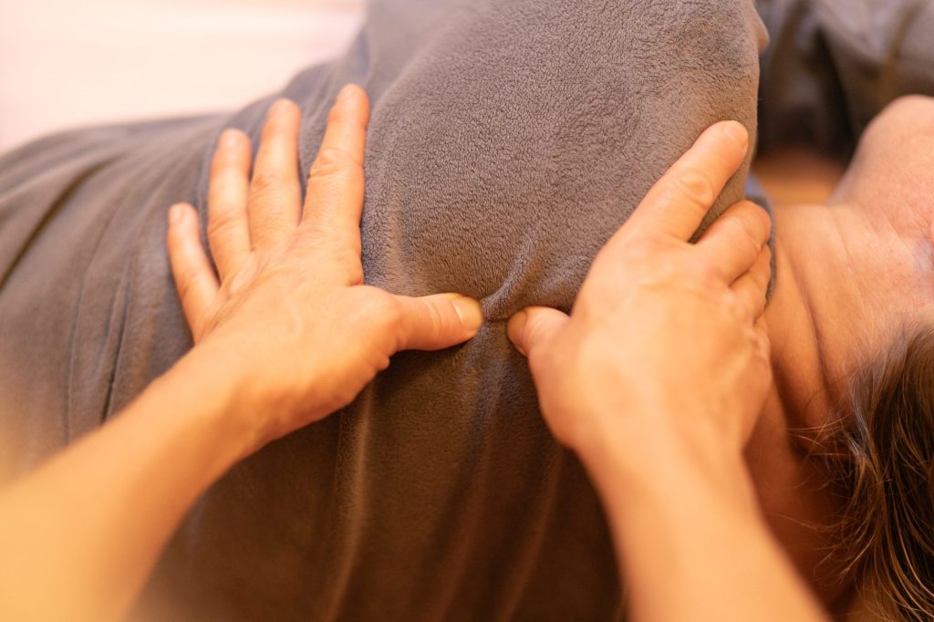 Gros plan sur une pression de shiatsu des deux mains sur les épaules